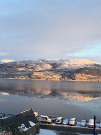 Scenic view of lake by mountains against sky