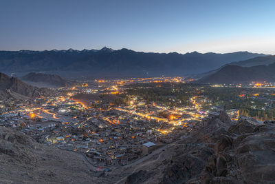 High angle view of illuminated cityscape against sky at night