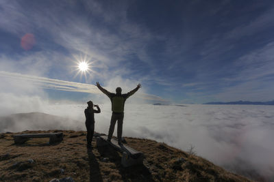 Friends standing on shore against sky