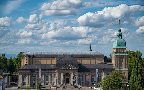 Buildings in city against cloudy sky