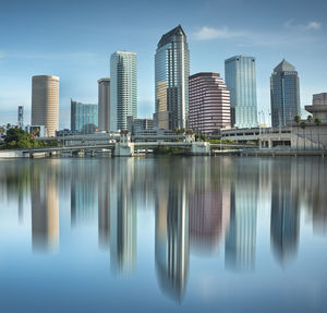 Reflection of buildings in city against sky