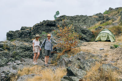 Happy young couple travelers in casual outfits on mountain background. local tourism, weekend trip