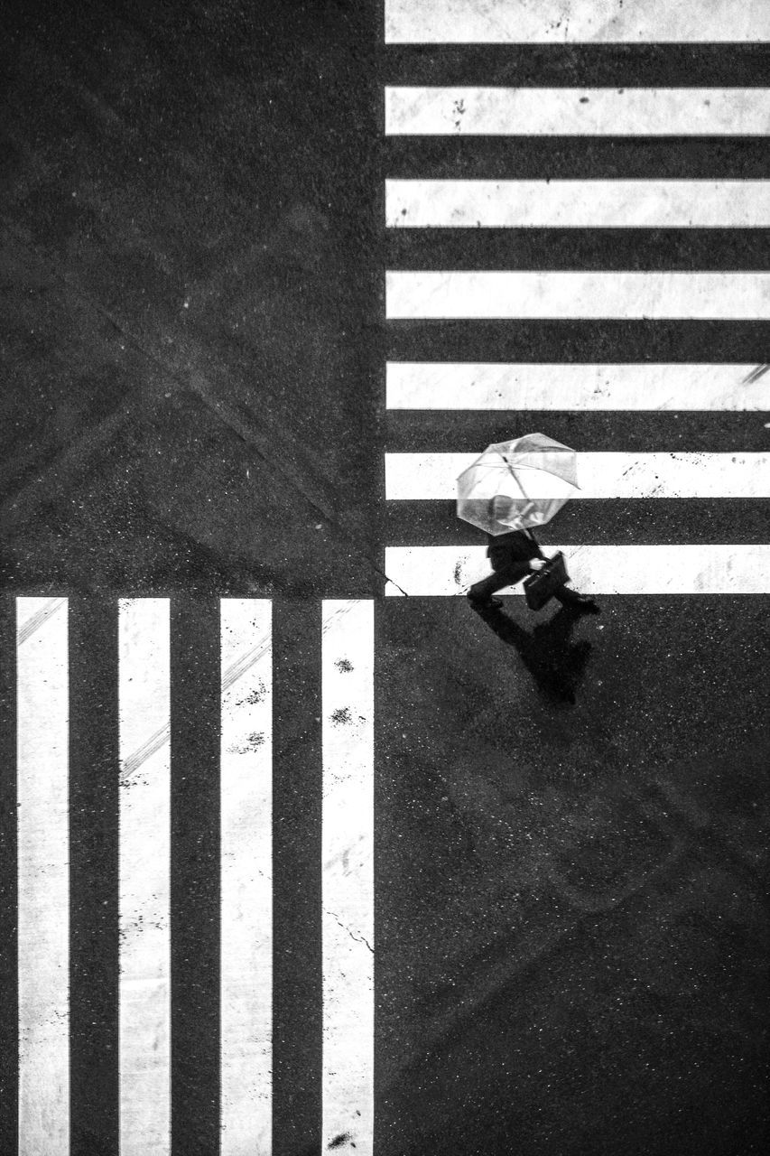 zebra crossing, striped, road marking, walking, high angle view, street, road, transportation, one person, full length, real people, day, outdoors, low section, men, adult, people