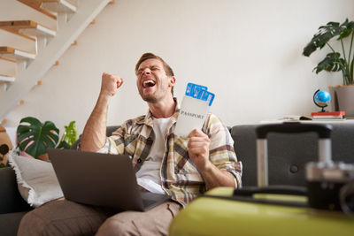 Young woman using phone while sitting at home