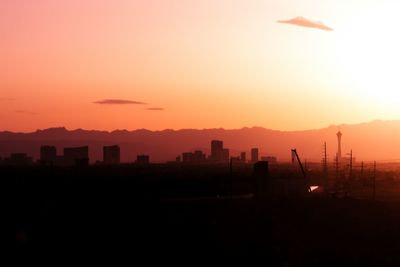 Silhouette landscape against orange sky
