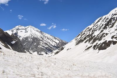 Scenic view of snowcapped mountains against blue sky