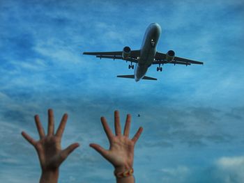 Low angle view of man flying airplane against sky