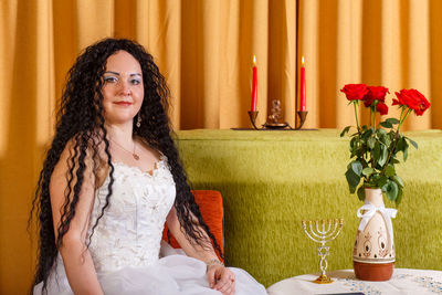 Portrait of woman sitting on table at home