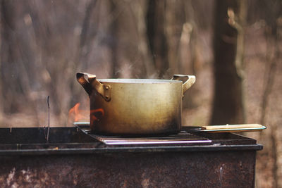 Close-up of metal container on barbecue grill