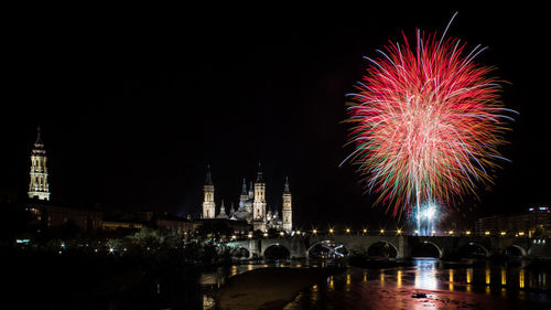 Firework display over river at night