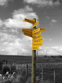 Information sign on landscape against cloudy sky