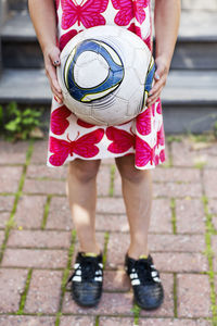 Girl holding soccer ball, low section, sollentuna, stockholm, sweden