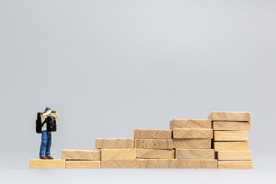 Full length of man standing on stack of wood