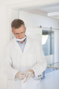 Midsection of man with arms raised standing against wall