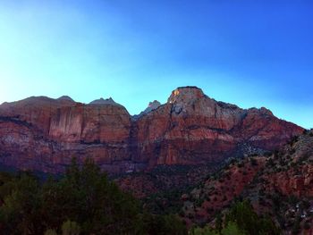 Low angle view of rocky mountains against clear sky