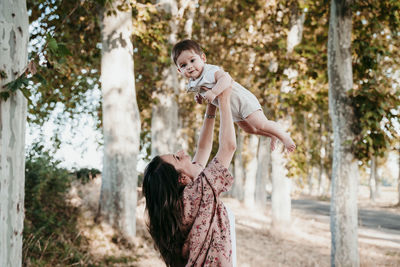 Mother and daughter against trees