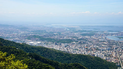 High angle view of town by sea against sky