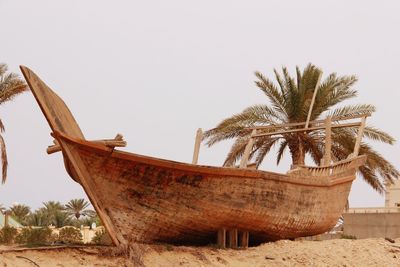 Low angle view of abandoned boat on beach against sky