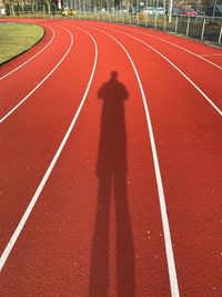 Shadow of man on running track