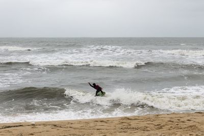 Silhouette of woman jumping on beach