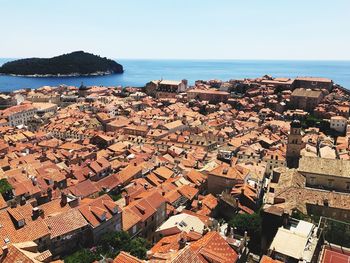 High angle view of townscape by sea against clear sky