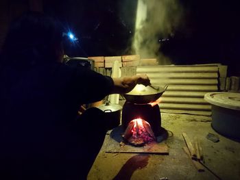 Midsection of man preparing food at night