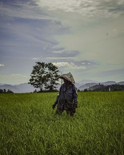 Man standing in farm against sky
