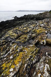 Aerial view of rocks in sea against sky