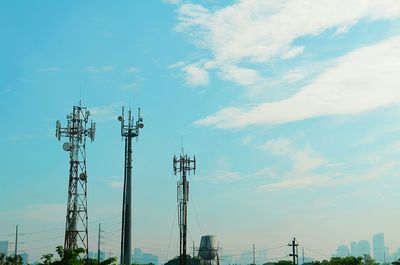 Low angle view of electricity pylon against blue sky