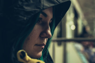 Close-up of thoughtful woman wearing hood sitting in vehicle