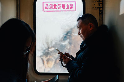 Side view of man using mobile phone