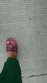 Low section of woman standing on brick wall