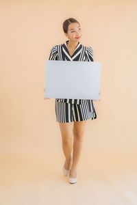 Full length of woman standing against white background