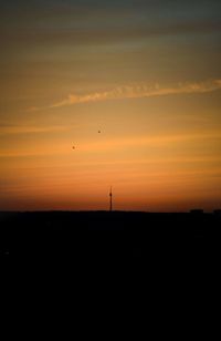 Scenic view of silhouette landscape against orange sky