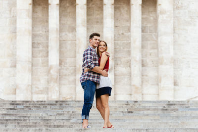 Side view of couple embracing while standing on steps