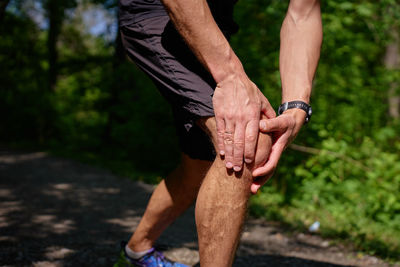 Low section of man tying shoelace