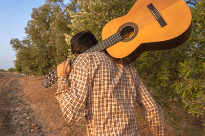 Rear view of man playing guitar