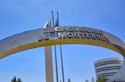 Low angle view of communications tower against blue sky