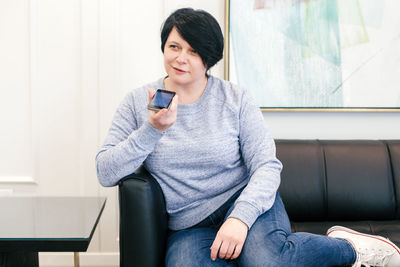 Mid adult man using mobile phone while sitting on table