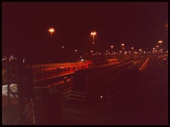 Road passing through illuminated city at night