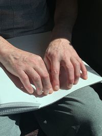 A man is reading a braille book 