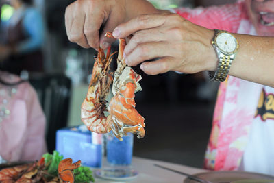 Closeup hands of man holding the steamed shrimp and clap.