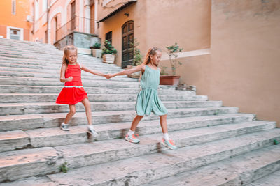 Women standing on staircase outside building