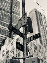 Low angle view of road sign on pole in city