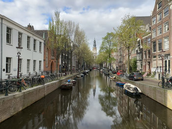 Boats in canal amidst buildings in city