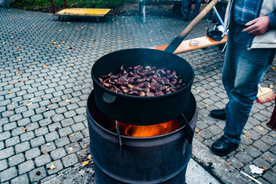 Low section of man standing on barbecue grill