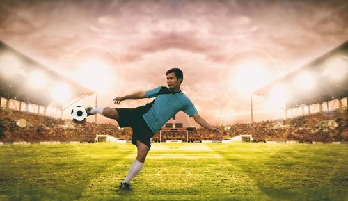 Digital composite image of soccer player kicking ball on field against sky