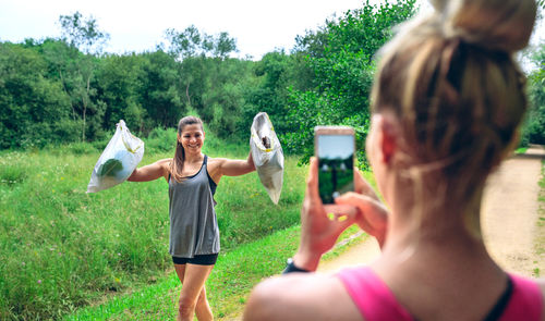 Rear view of woman photographing on mobile phone