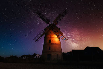 Low angle view of traditional windmill against sky at night