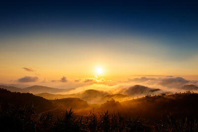Scenic view of silhouette mountains against sky during sunset